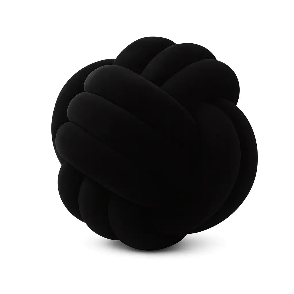 Almofada de nó escandinavo decorativa em composição minimalista sobre cama ou poltrona, nas cores verde claro e preto.