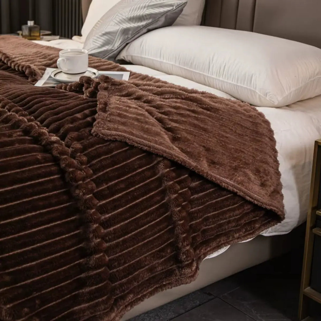 Cobertor de flanela listrada realçando o visual da cama em um quarto aconchegante.