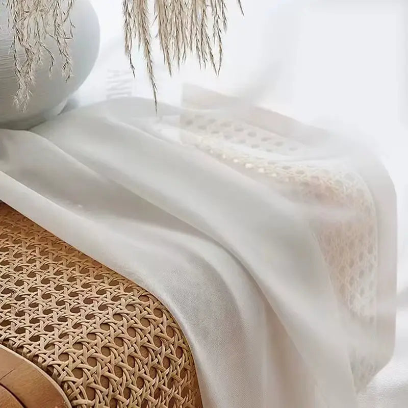 Detalhe da textura delicada e translúcida da cortina de tule voile, ideal para uma decoração refinada.