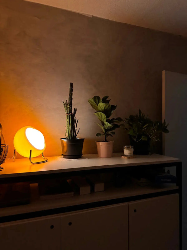Luminária de Mesa Bauhaus Medieval LED exibida em ambiente interno, combinando o charme retro com a elegância nórdica. Seu abajur em vidro claro do leite e base texturizada em aço inoxidável proporcionam uma iluminação suave e sofisticada.