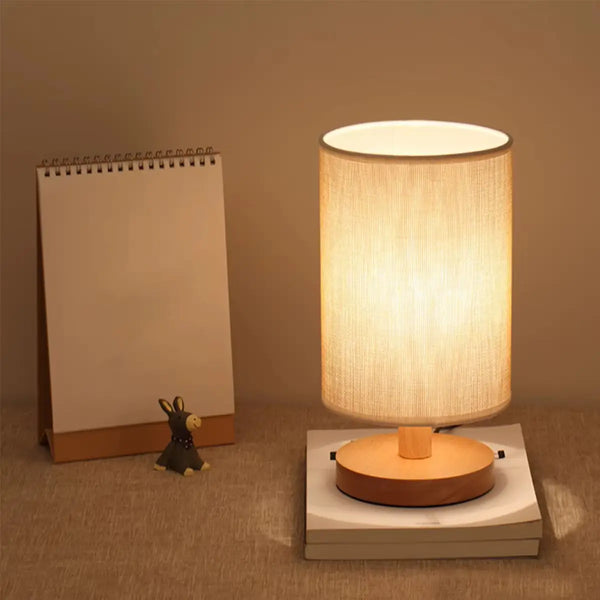 Luminária de mesa de linho com toque sensível exibida em um ambiente minimalista, destacando seu design elegante com abajur de linho e base de madeira.