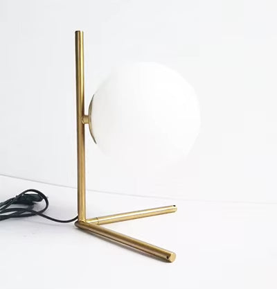 Luminária Nordic Gold posicionada na mesa de cabeceira, proporcionando um toque refinado à decoração do quarto.