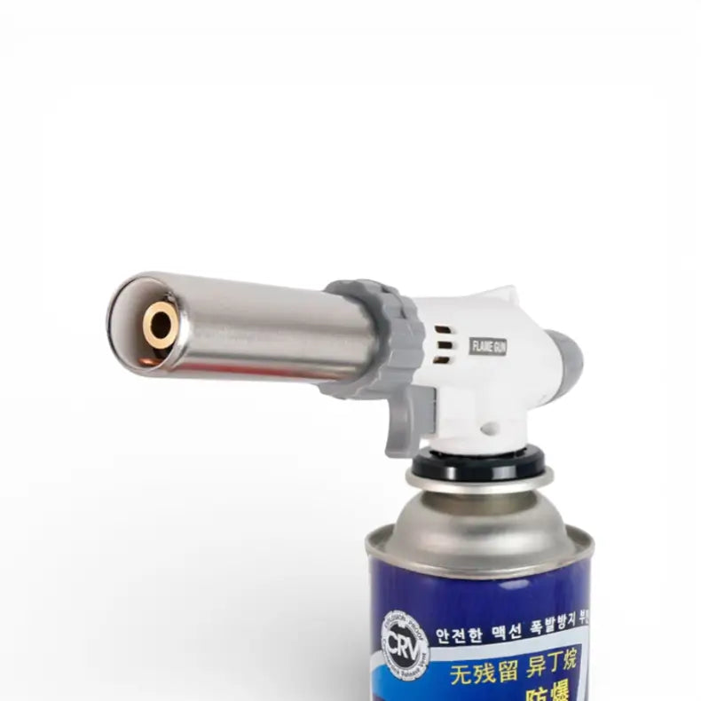 Maçarico culinário profissional branco posicionado na bancada de cozinha moderna ao lado de ingredientes e sobremesas