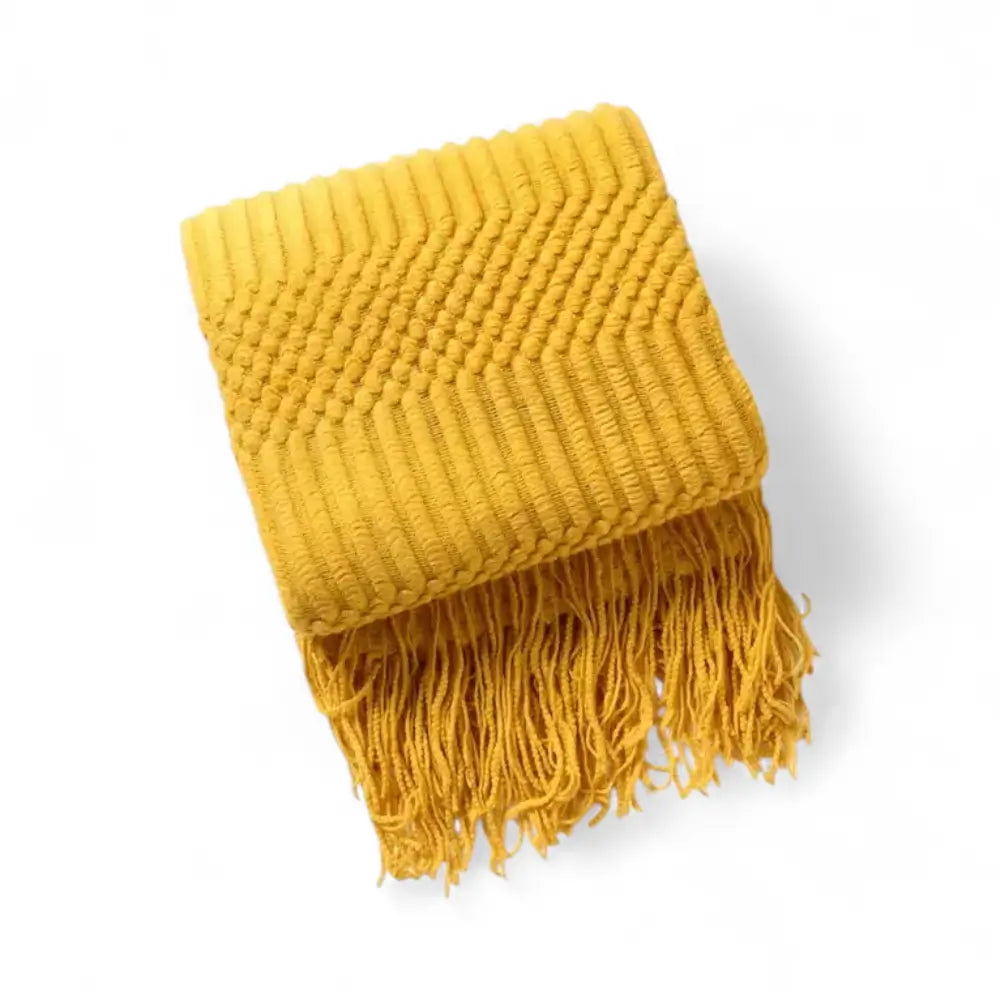 Manta de malha clássica com franjas usada como peça decorativa sofisticada.