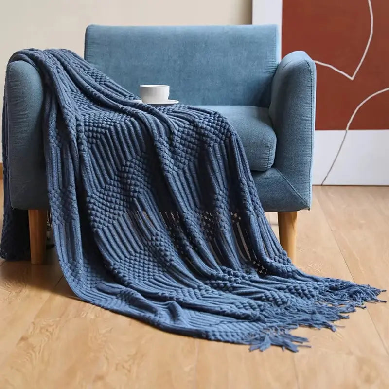 Manta de malha clássica com franjas, versátil para uso em diferentes ambientes.